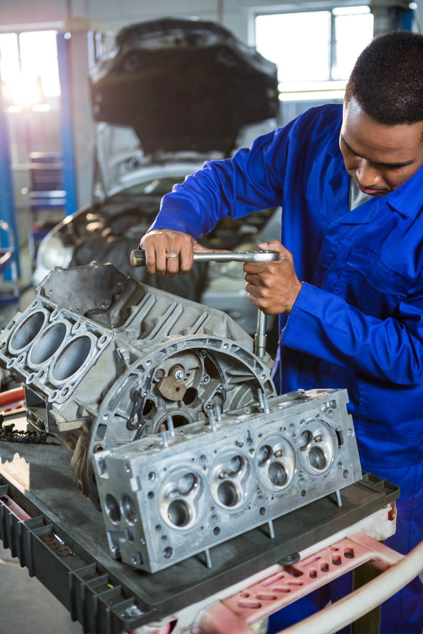 Mechanic repairing engine part with ratchet at the repair garage